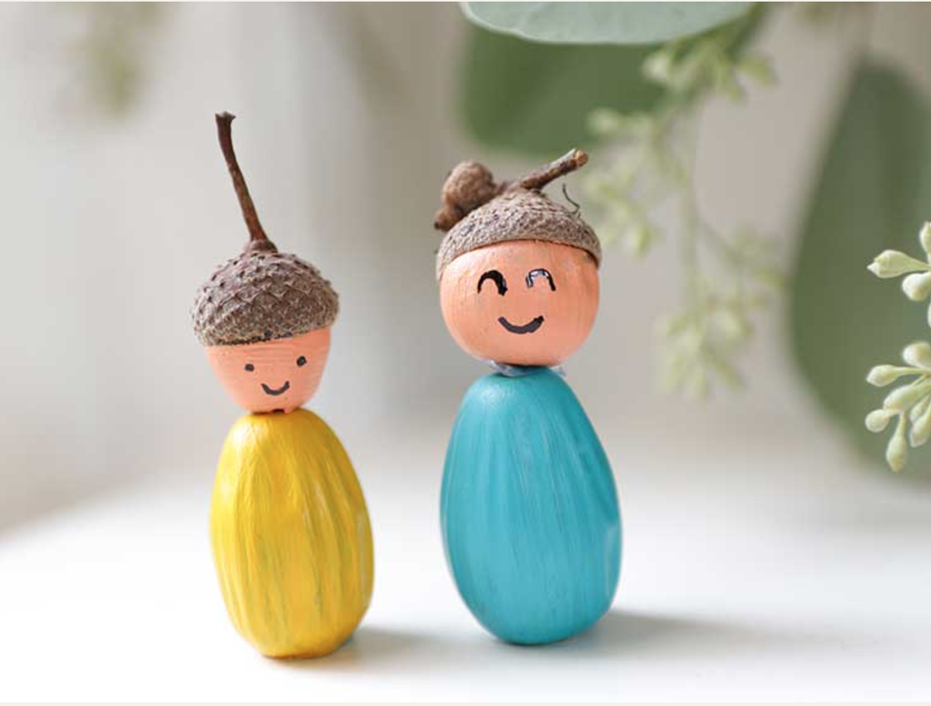Twee gekleurde poppetjes gemaakt van eikels